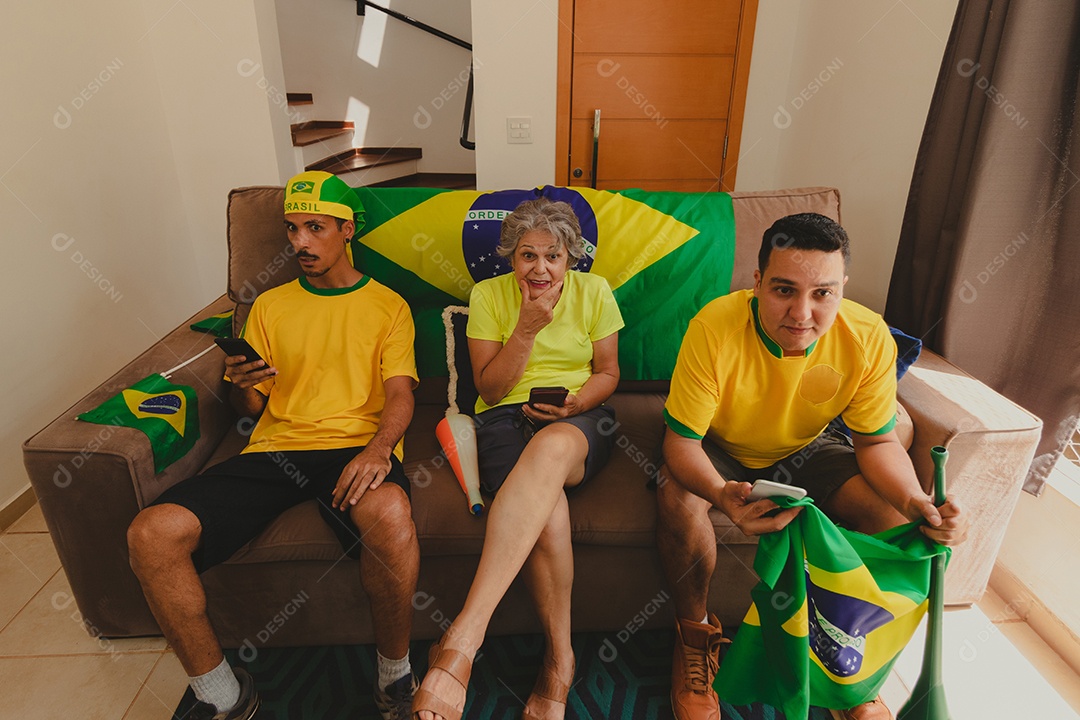 Família mestiça brasileira Comemorando a copa na sala assistindo jogo de futebol.