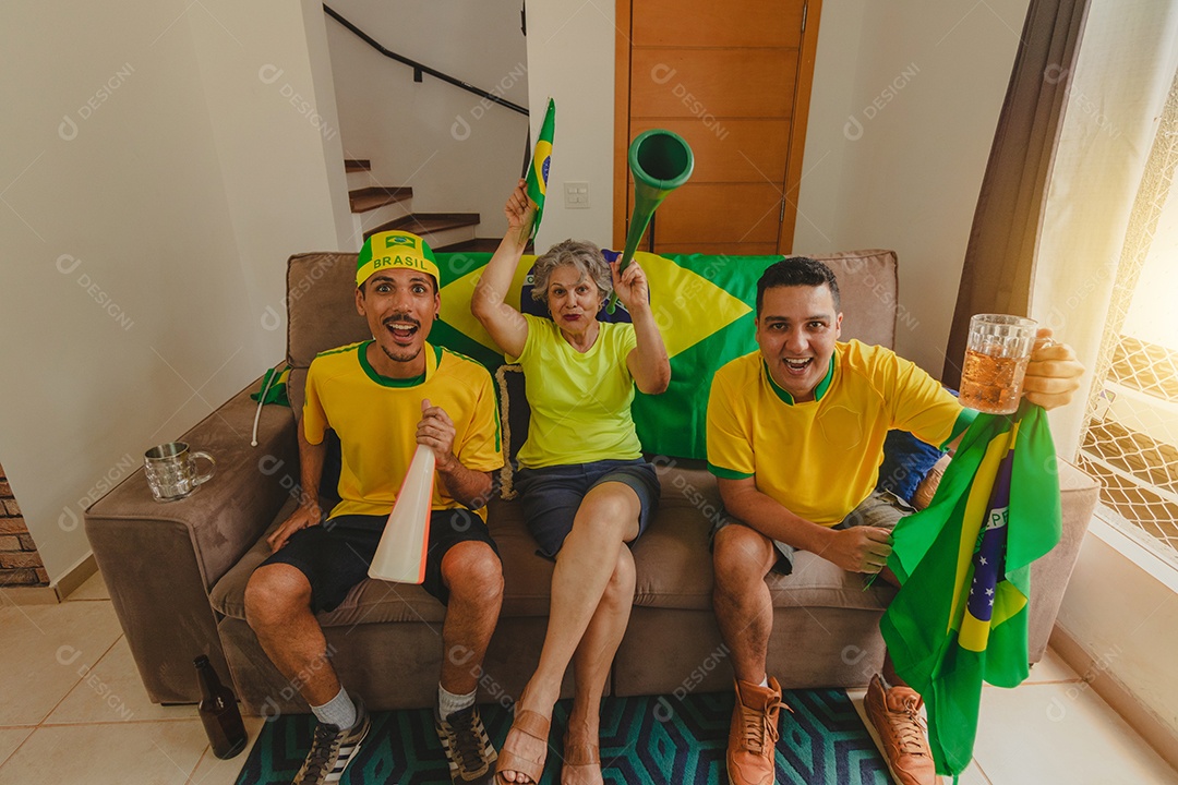Família mestiça brasileira Comemorando a copa na sala assistindo jogo de futebol.