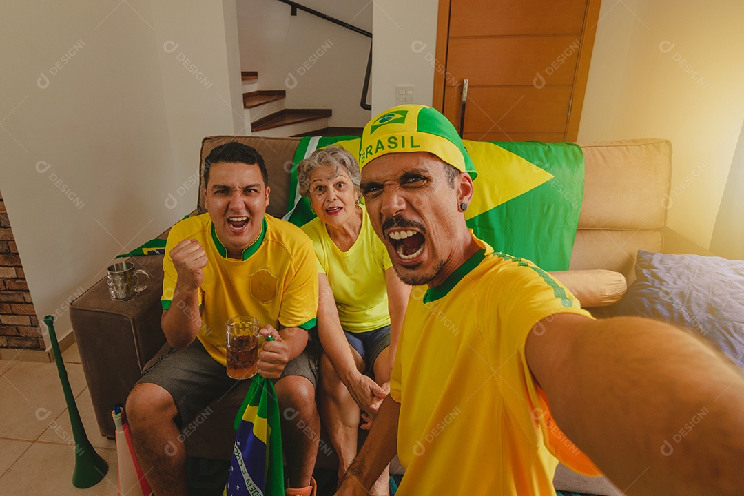 Família mestiça brasileira Comemorando a copa na sala assistindo jogo de futebol.