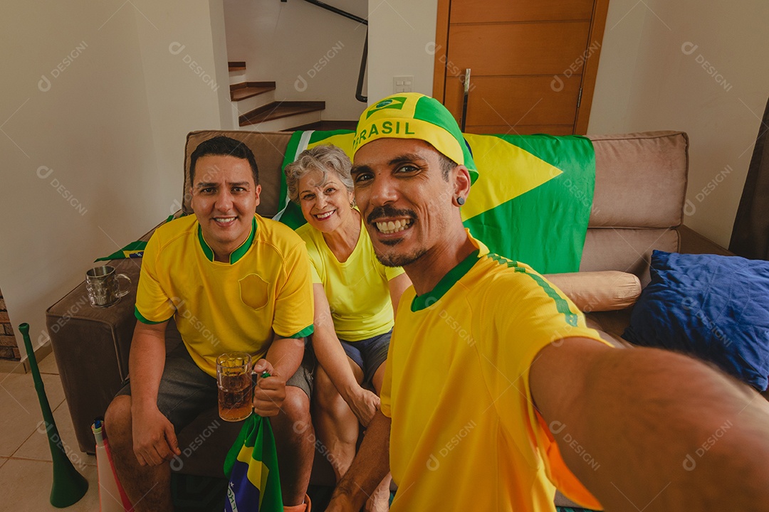 Família mestiça brasileira Comemorando a copa na sala assistindo jogo de futebol.