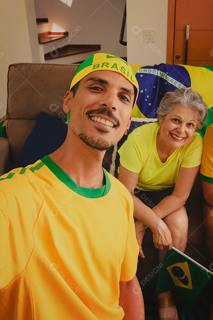 Família mestiça brasileira Comemorando a copa na sala assistindo jogo de futebol.