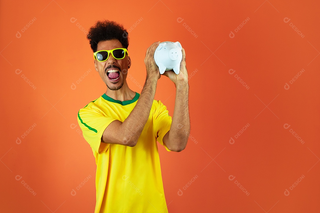 Jogador de futebol - homem negro comemorando segurando painel solar fotovoltaico isolado em laranja