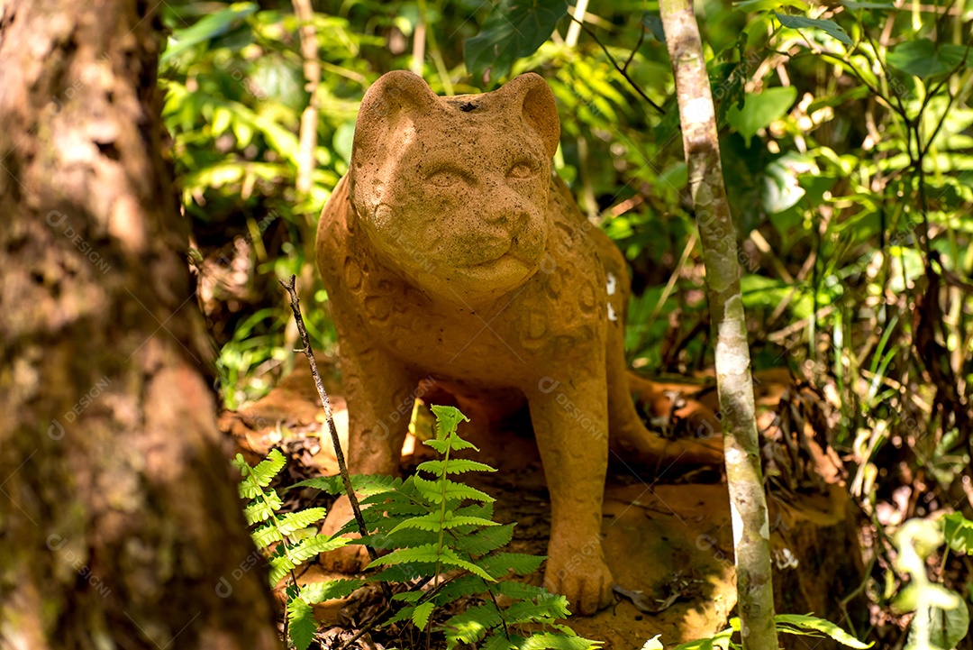 Estátua de pedra de um gato na floresta.