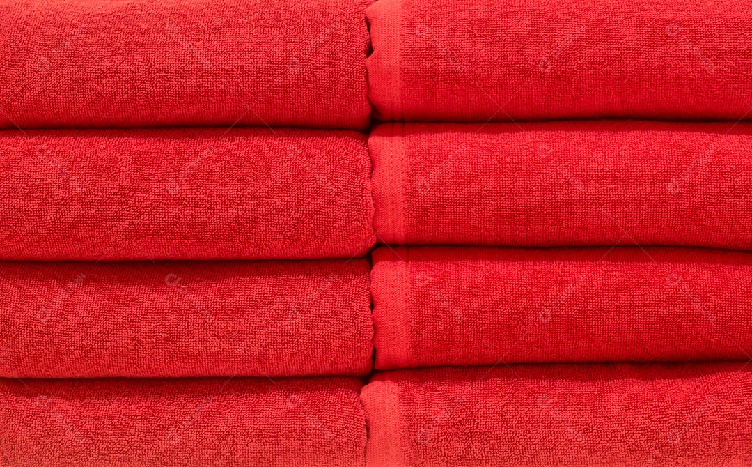 Lindas toalhas de banho vermelhas cuidadosamente dobradas nas prateleiras do departamento