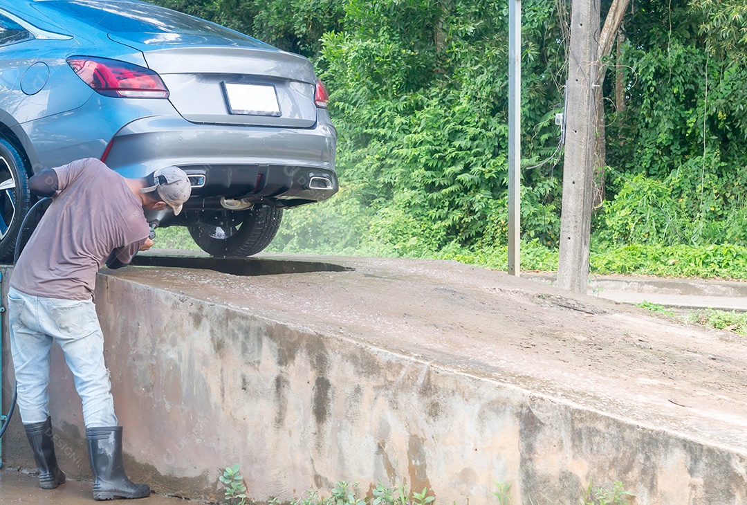 Lavadores de carros no serviço de atendimento automotivo estão lavando um carro do cliente.