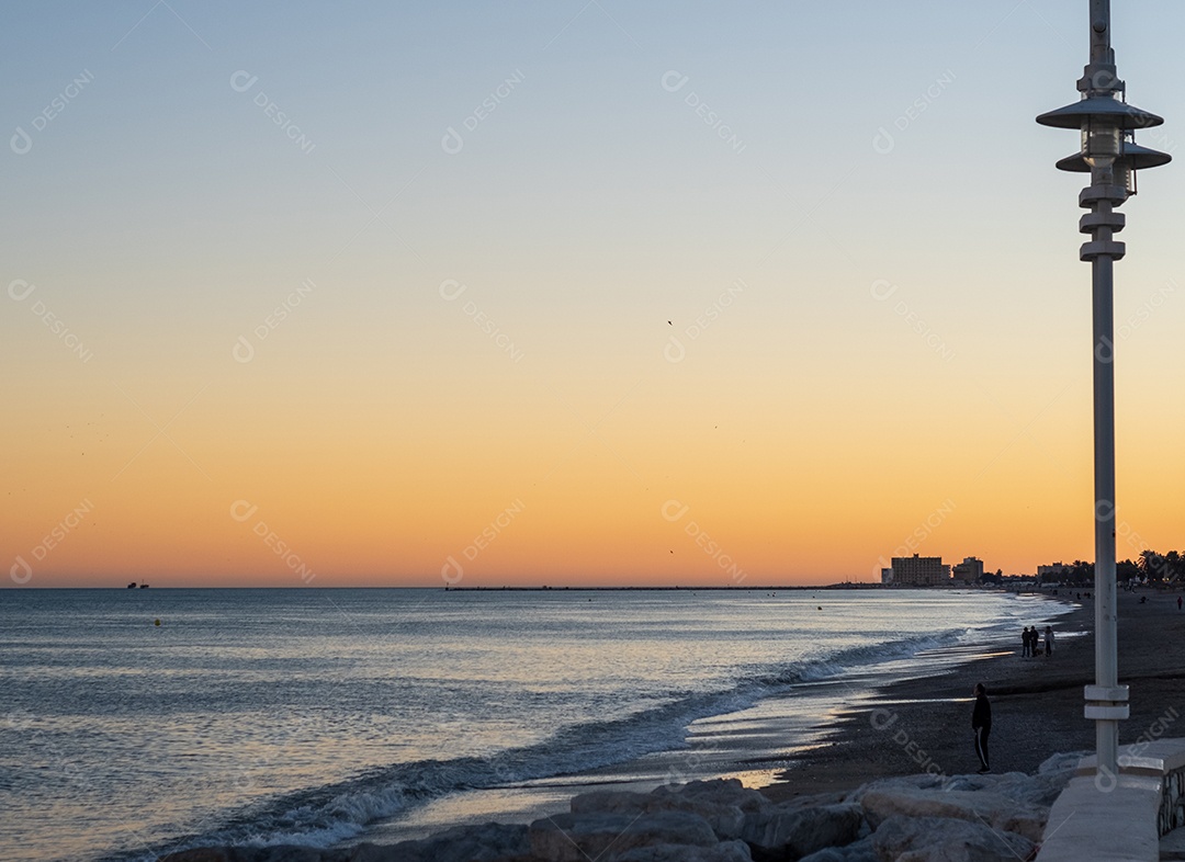 Vista da praia de Málaga ao entardecer.