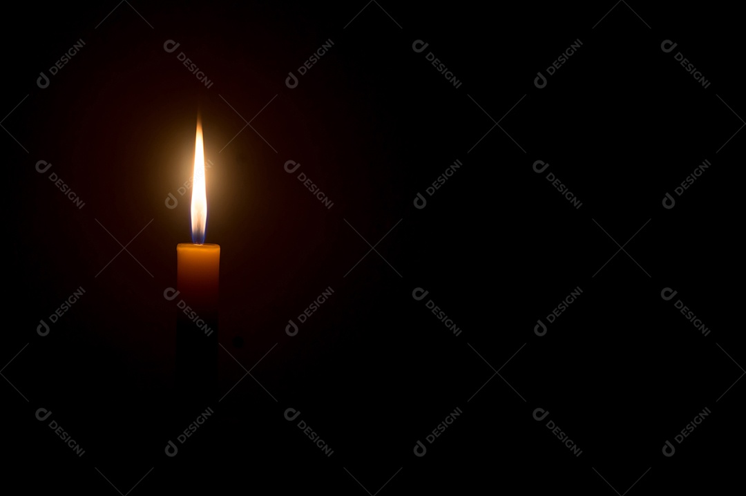 Vela acesa ou luz brilhando em uma vela amarela