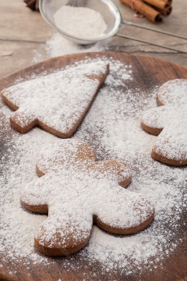 Biscoitos de gengibre de natal tradicionais sobre uma mesa de madeira.