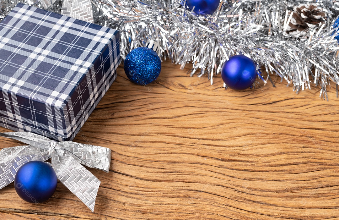 Bolas de natal vermelhas, douradas e prateadas e laços de presente sobre madeira