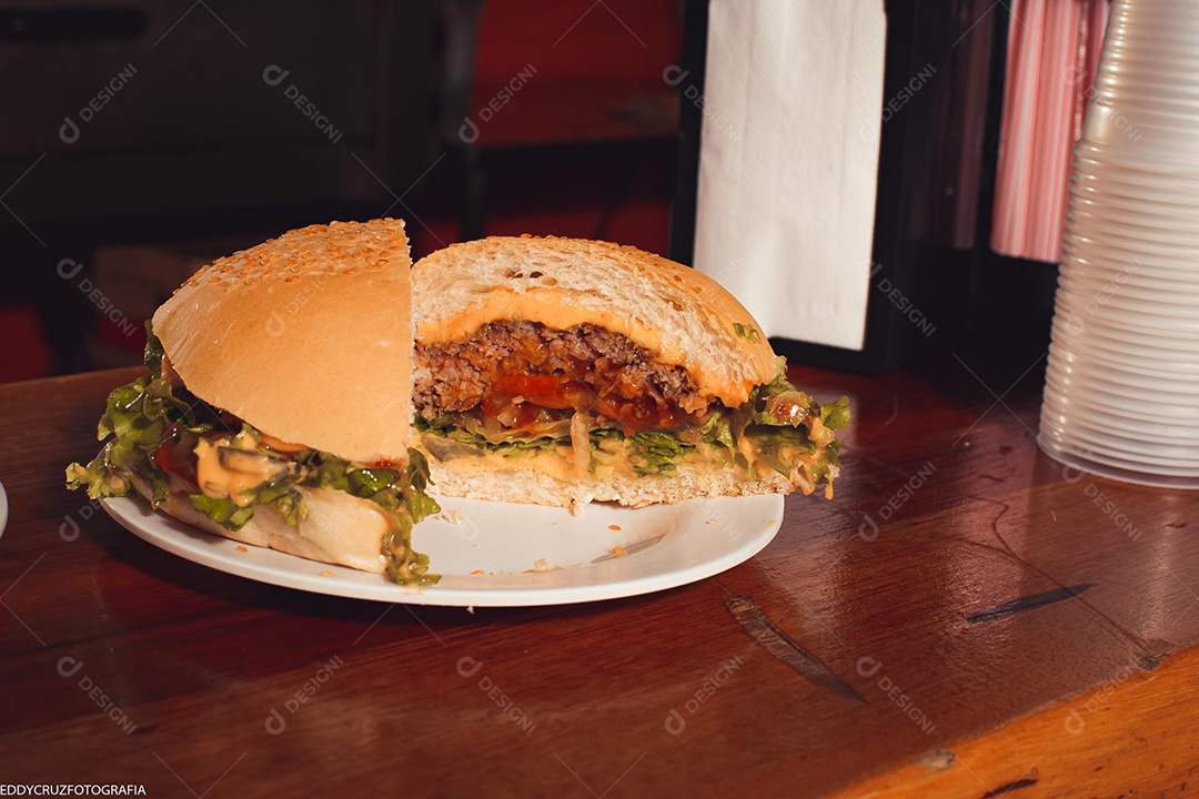 Hamburgueres sendo servidos em lanchonete.