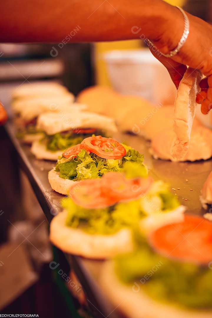 Pessoa montando sanduiches naturais em maior quantidade.