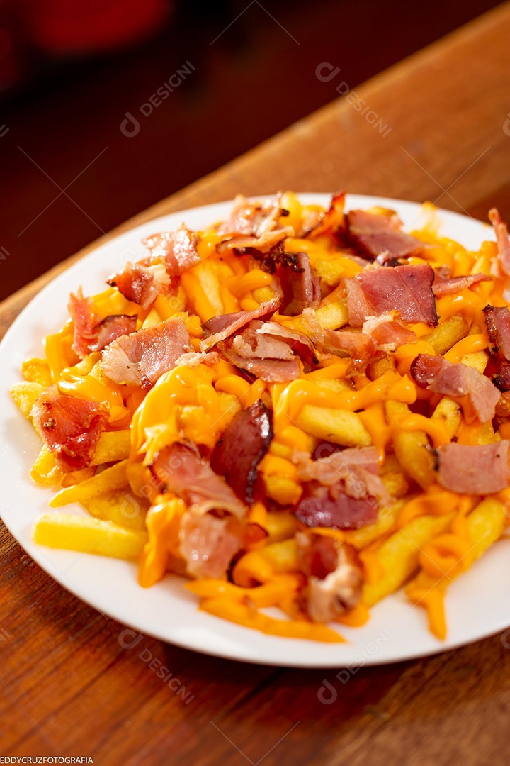 Porção de batata frita com cheddar e bacon servidos em um prato branco.