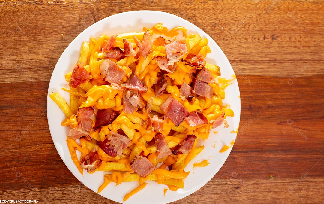 Porção de batata frita com cheddar e bacon servidos em um prato branco.