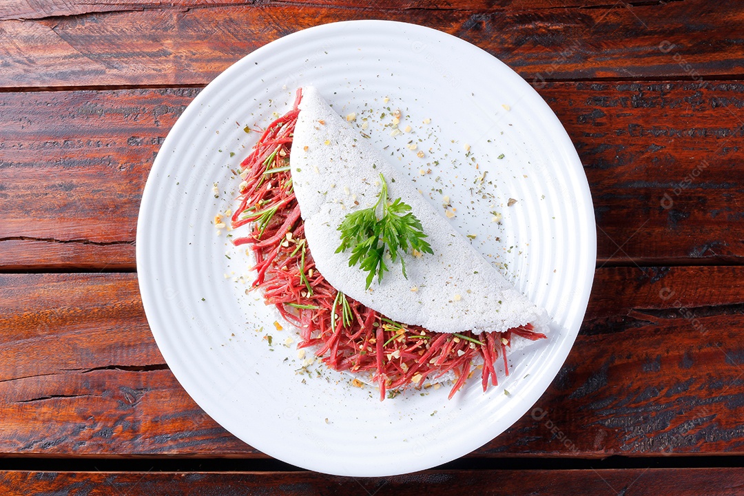 Tapioca ou beiju recheado com carne seca, carne de sol em mesa rústica de madeira. Comida típica brasileira. vista do topo