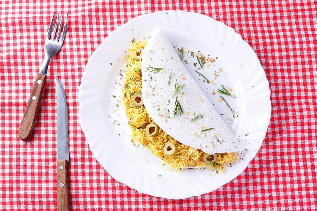 tapioca caseira ou beiju recheado com frango cozido e azeitonas na mesa de madeira rústica. vista do topo