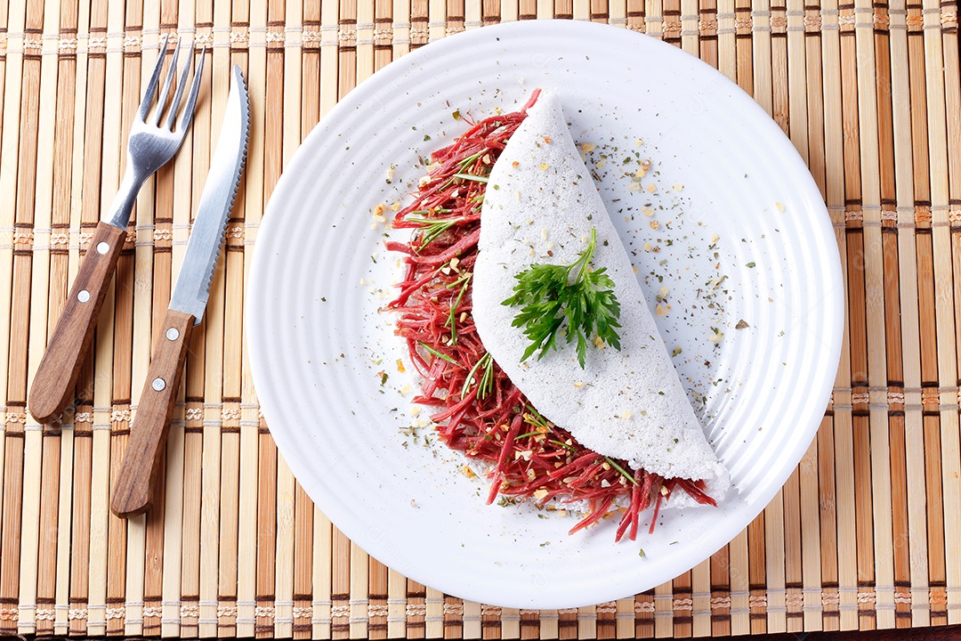 Tapioca ou beiju recheado com carne seca, carne de sol em mesa rústica de madeira. Comida típica brasileira. vista do topo