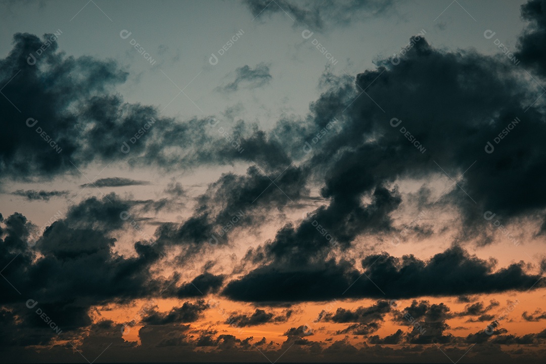 Vista do nascer do sol com nuvens dramáticas e céu colorido.