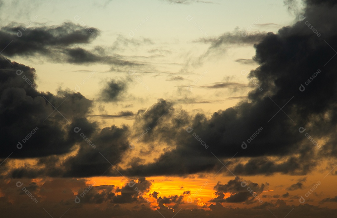 Vista do nascer do sol com nuvens dramáticas e céu colorido.