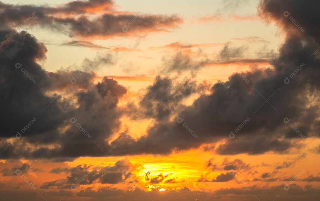 Vista do nascer do sol com nuvens dramáticas e céu colorido.