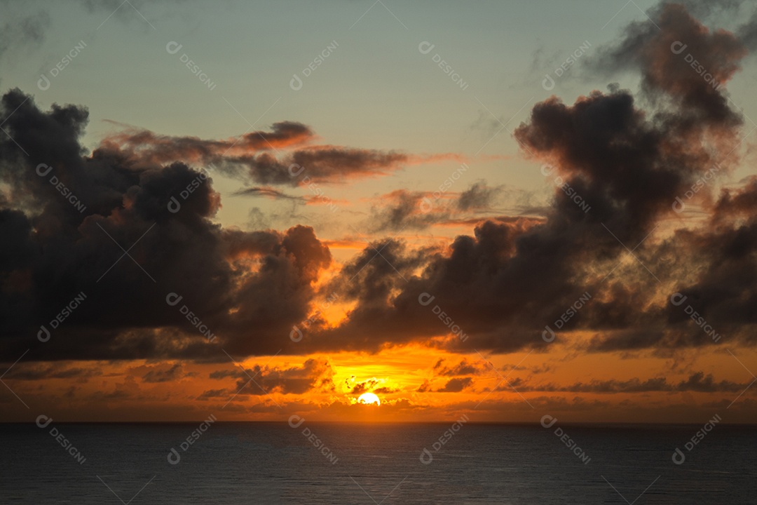 Vista do nascer do sol com nuvens dramáticas e céu colorido.