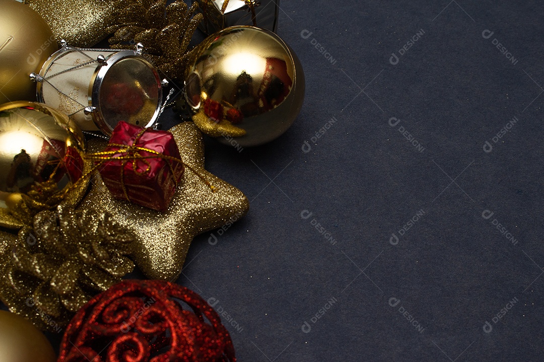 various gold and red christmas ornaments on black background