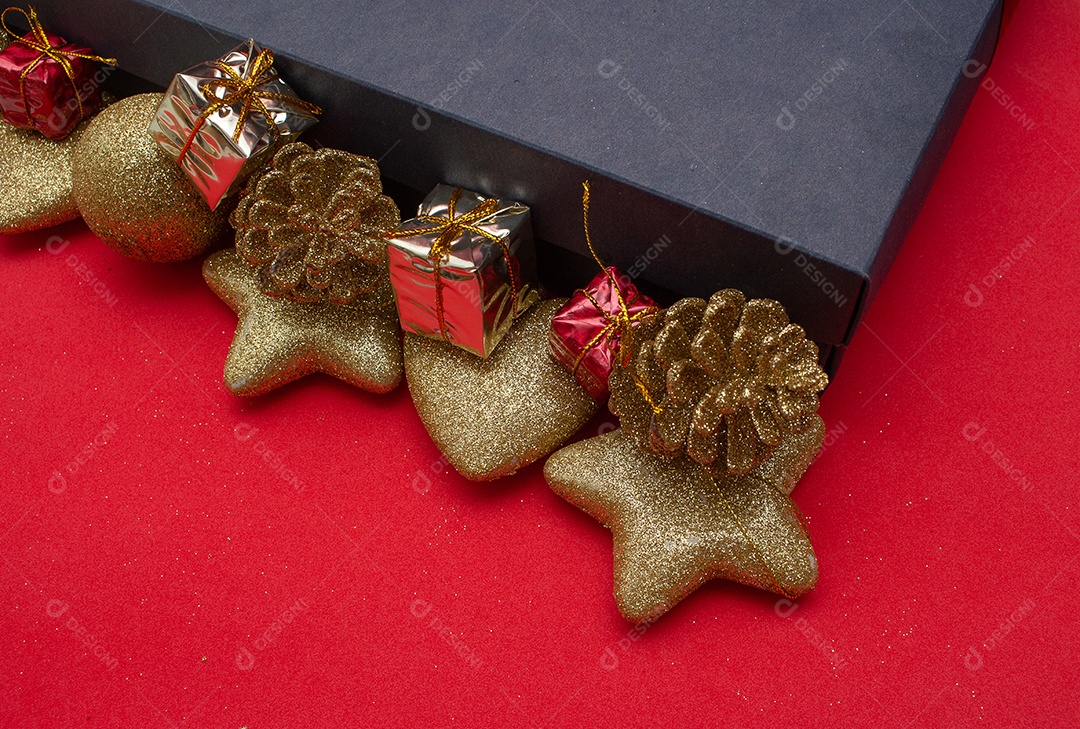 caixa de presente com vários enfeites de natal ao redor