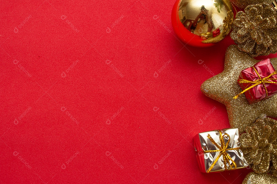 vários enfeites de natal dourados em fundo vermelho
