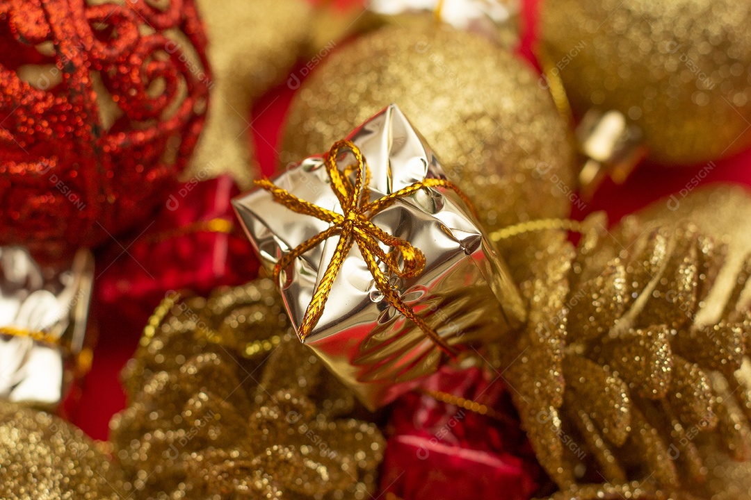 vários enfeites de natal dourados em fundo vermelho