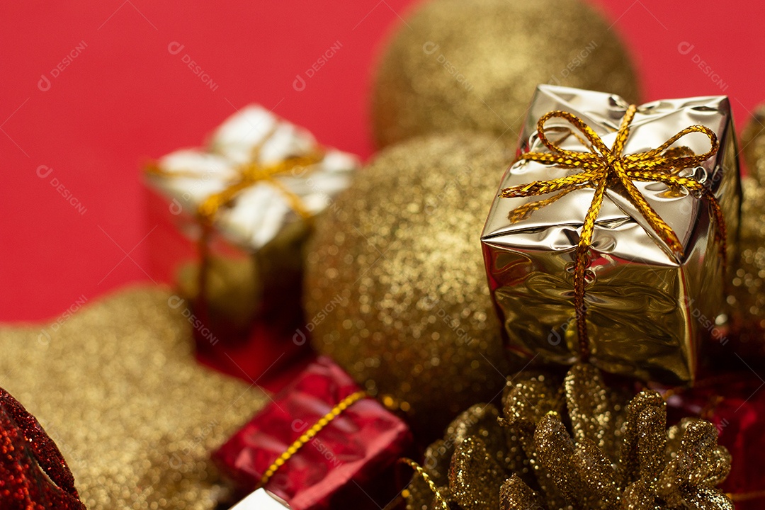 vários enfeites de natal dourados em fundo vermelho