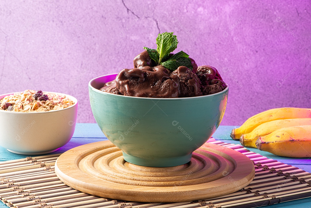 Tigela de sorvete de açaí congelado brasileiro. com frutas em fundo de madeira.