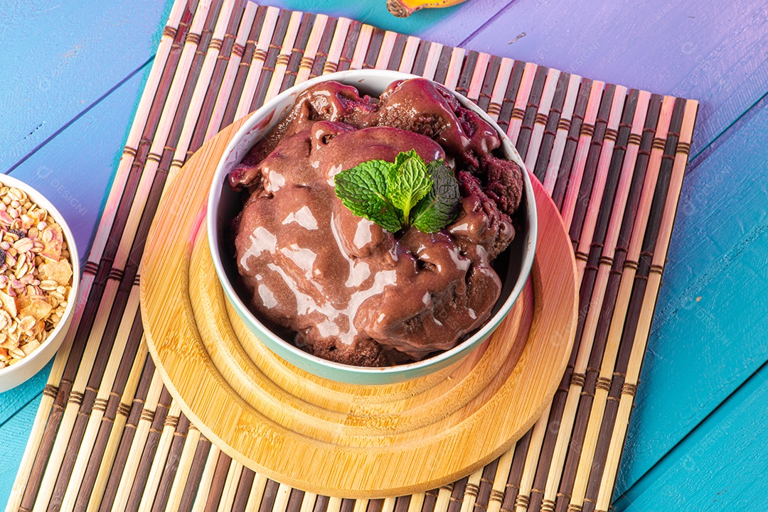 Tigela de sorvete de açaí congelado brasileiro. com frutas em fundo de madeira.