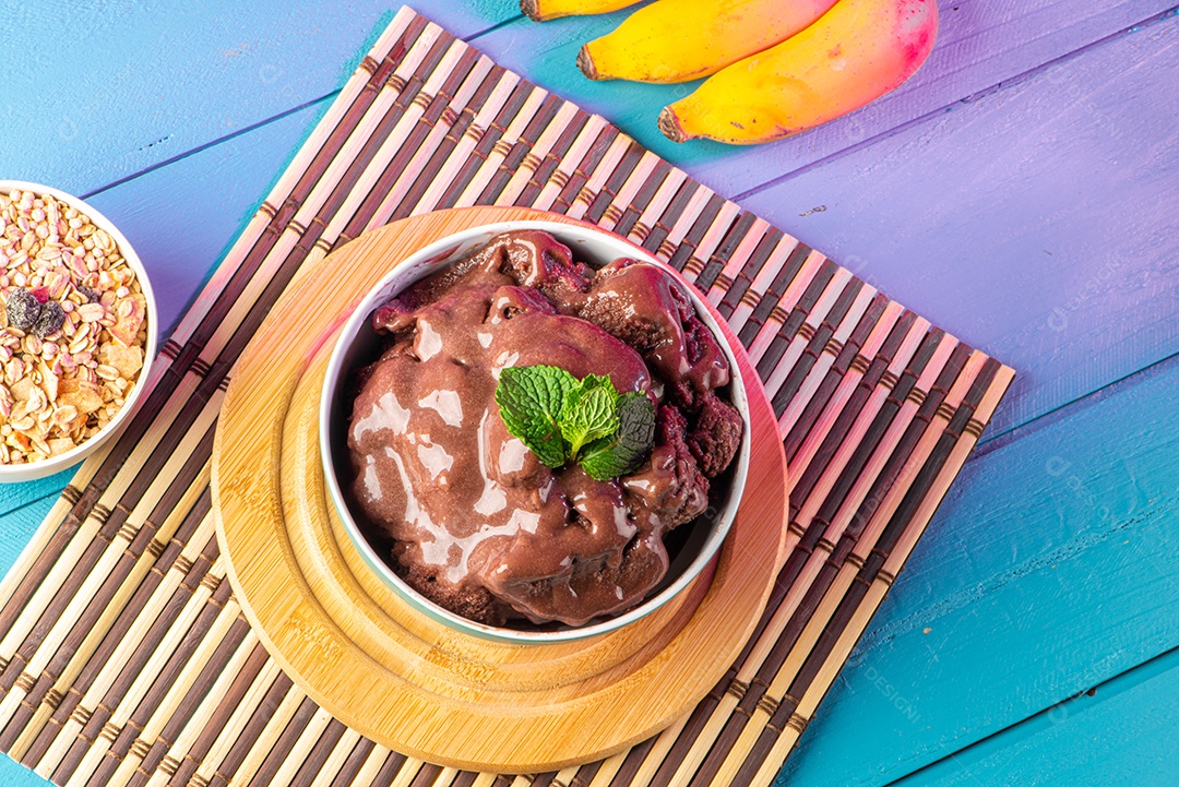 Tigela de sorvete de açaí congelado brasileiro. com frutas em fundo de madeira.