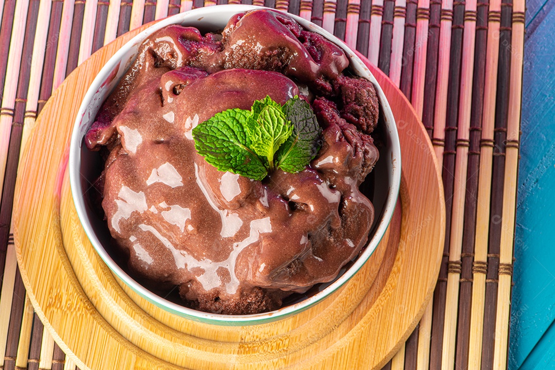 Tigela de sorvete de açaí congelado brasileiro. com frutas em fundo de madeira.