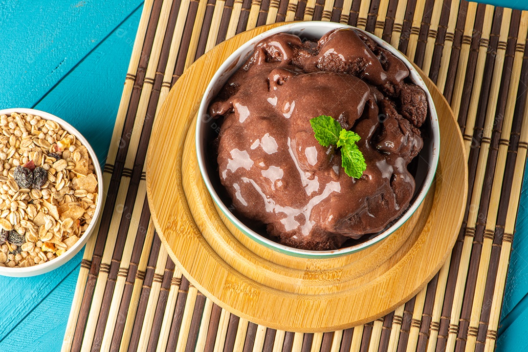 Tigela de sorvete de açaí congelado brasileiro. com frutas em fundo de madeira.