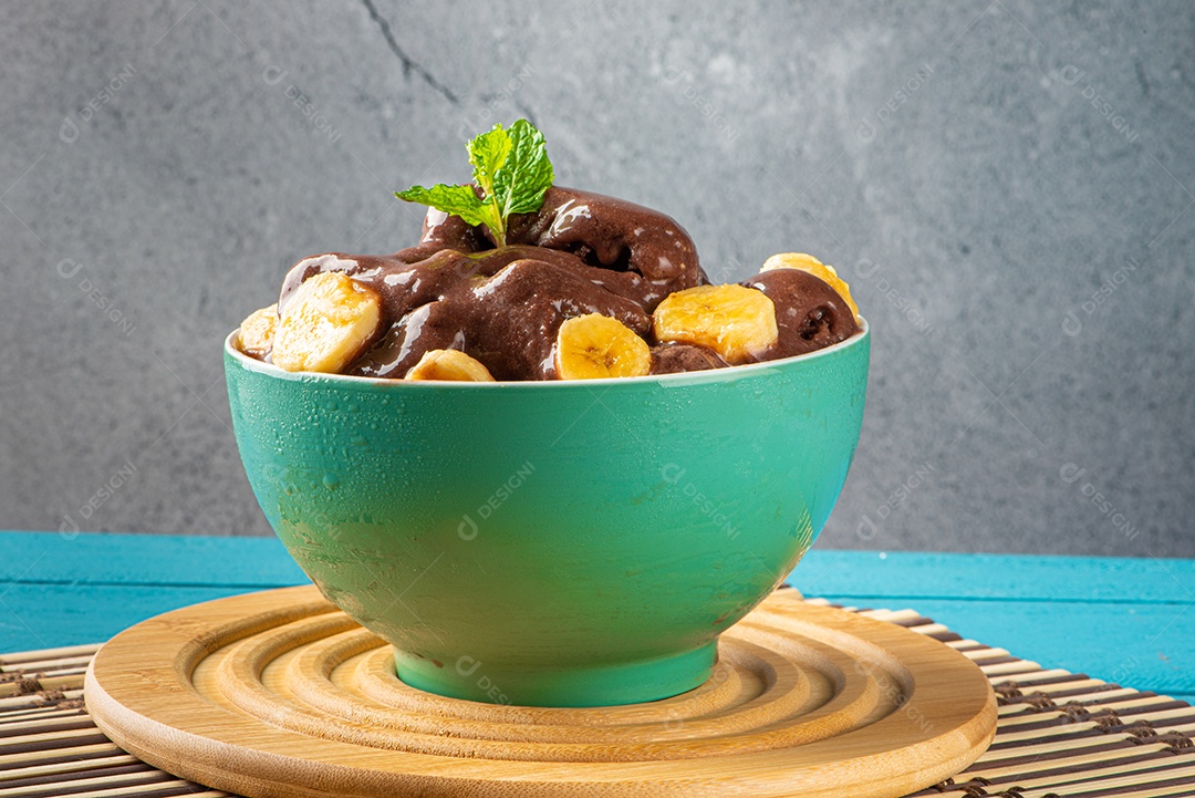 Tigela de sorvete de açaí congelado brasileiro. com frutas em fundo de madeira.