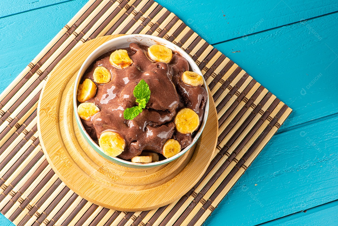 Tigela de sorvete de açaí congelado brasileiro. com frutas em fundo de madeira.