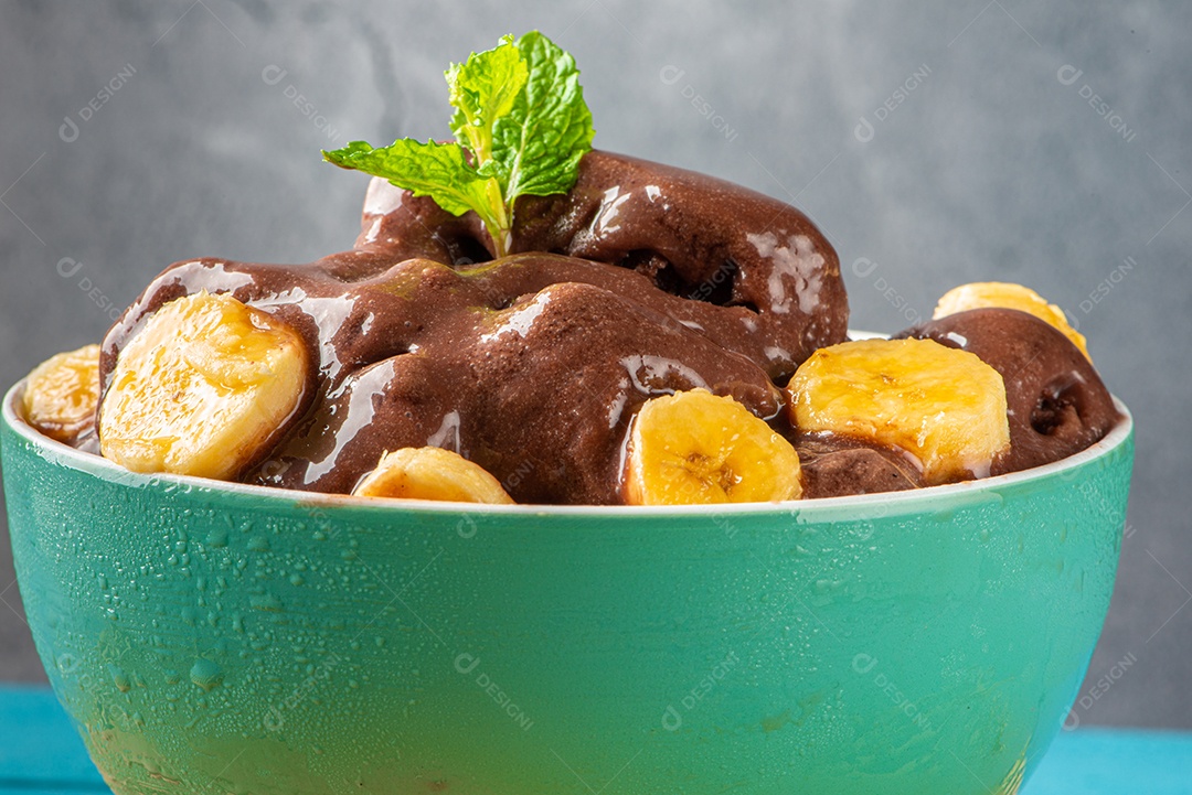 Tigela de sorvete de açaí congelado brasileiro. com frutas em fundo de madeira.