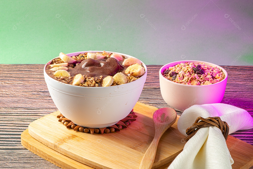 Tigela de sorvete de açaí congelado brasileiro. com frutas em fundo de madeira.