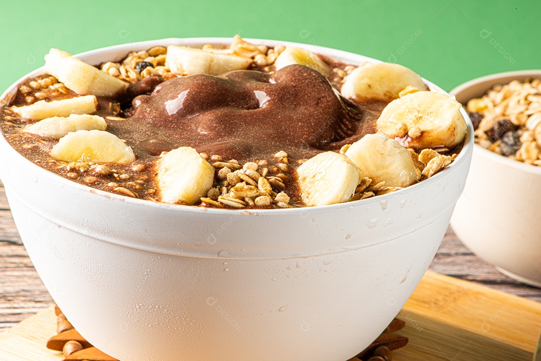 Tigela de sorvete de açaí congelado brasileiro. com frutas em fundo de madeira.