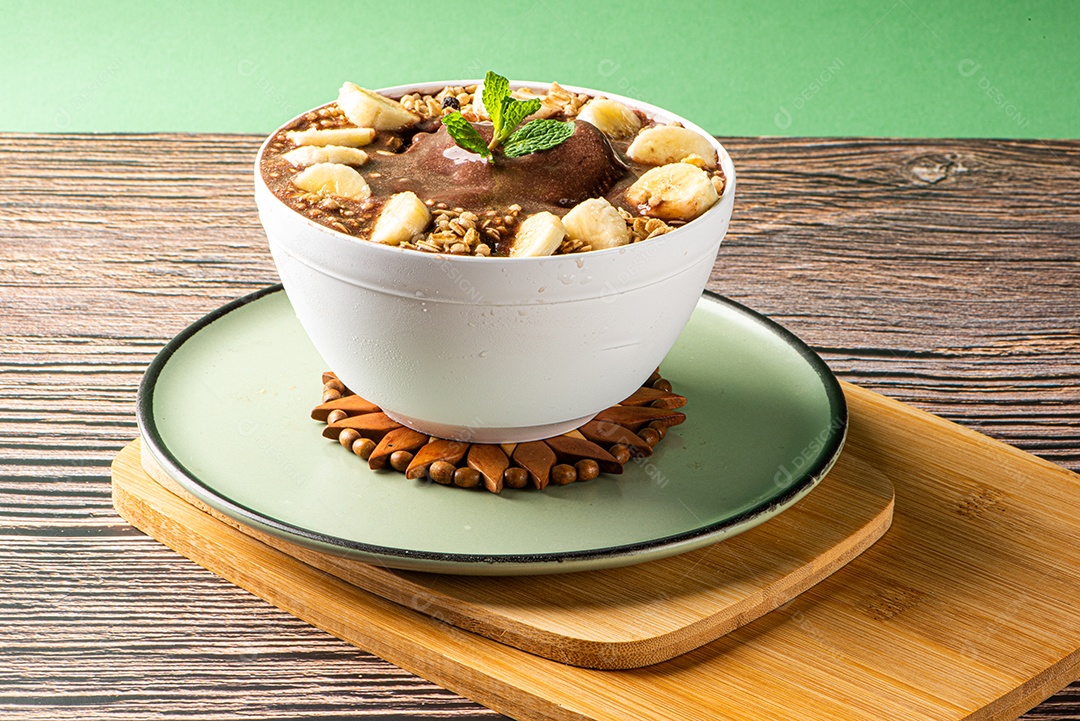 Tigela de sorvete de açaí congelado brasileiro. com frutas em fundo de madeira.