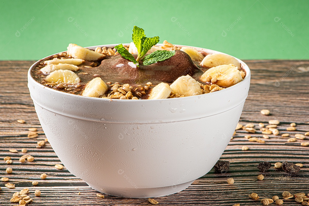 Tigela de sorvete de açaí congelado brasileiro. com frutas em fundo de madeira.