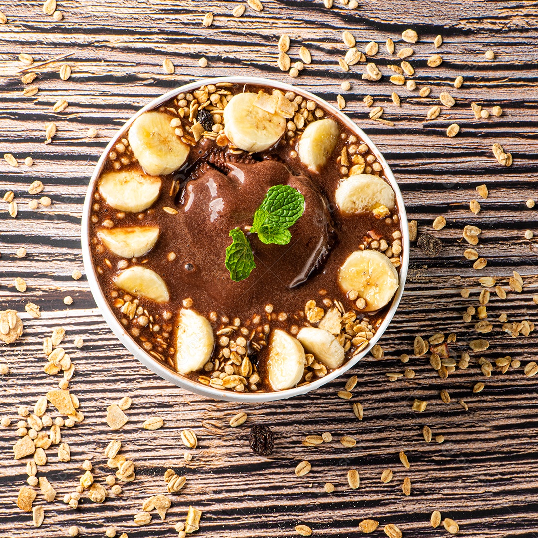 Tigela de sorvete de açaí congelado brasileiro. com frutas em fundo de madeira.