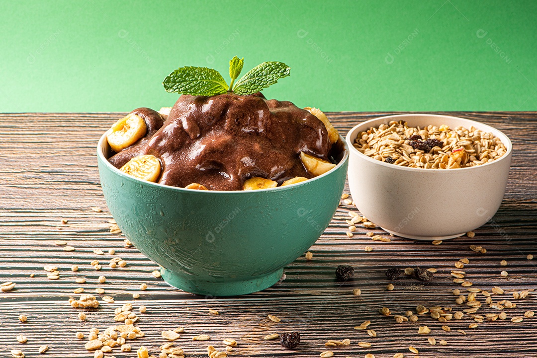 Tigela de sorvete de açaí congelado brasileiro. com frutas em fundo de madeira.