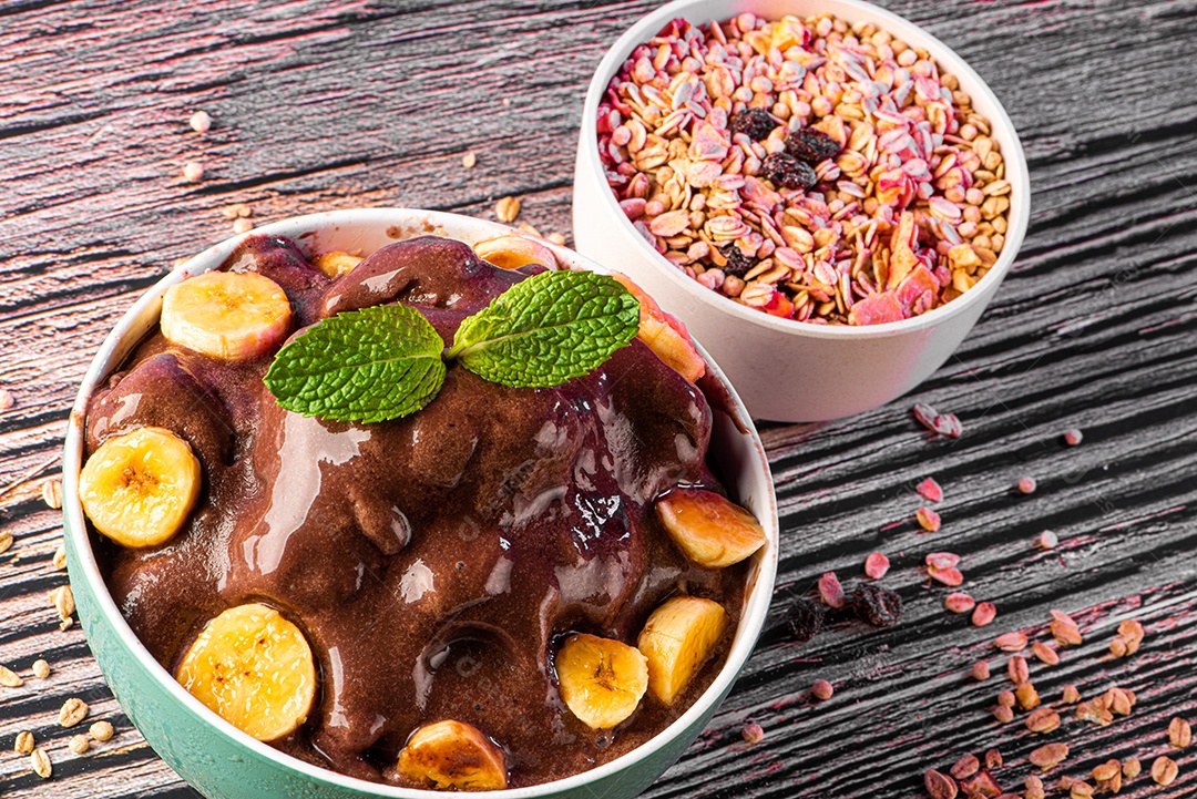 Tigela de sorvete de açaí congelado brasileiro. com frutas em fundo de madeira.