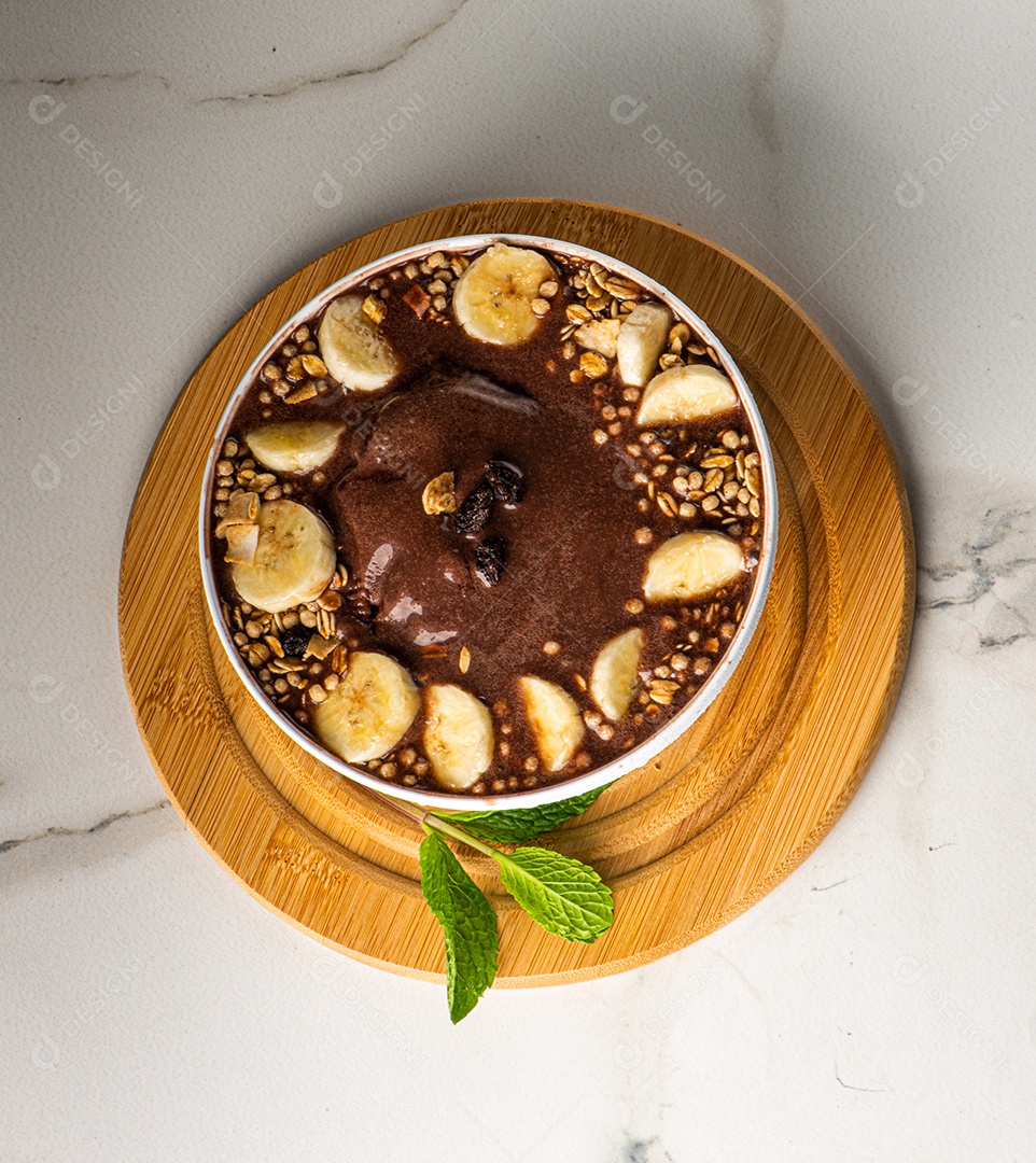 Tigela de sorvete de açaí congelado brasileiro. com frutas em fundo de madeira.