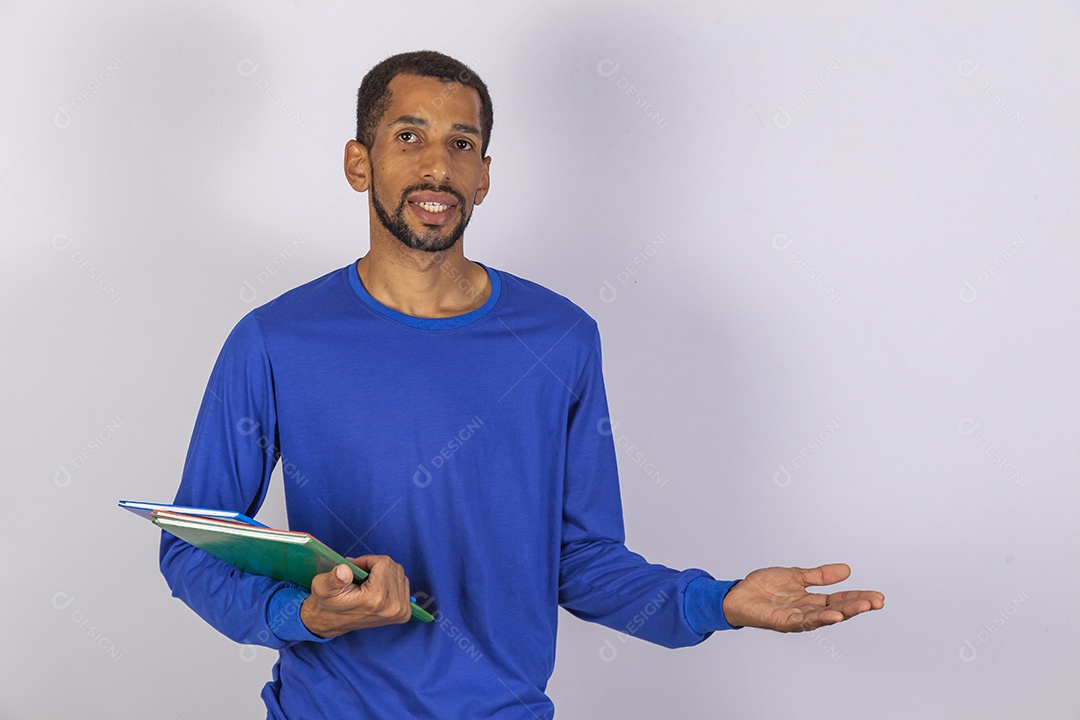 Homem jovem usando camiseta azul segurando material escolar escola