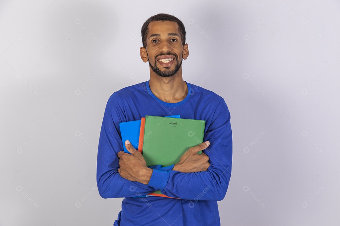 Homem jovem usando camiseta azul segurando material escolar escola