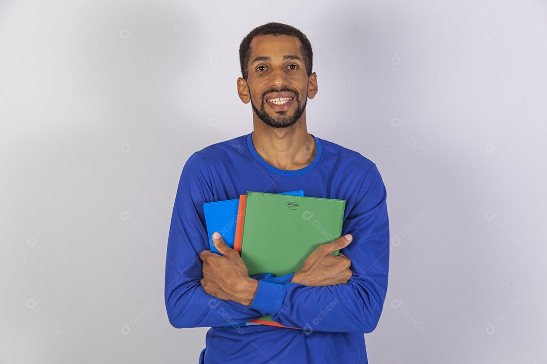 Homem jovem usando camiseta azul segurando material escolar escola
