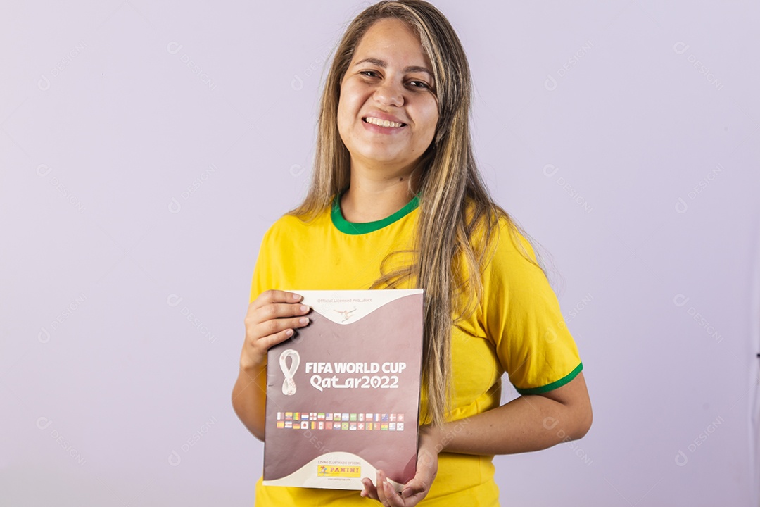 Linda mulher jovem morena segurando álbum da copa do brasil de 2022 futebol