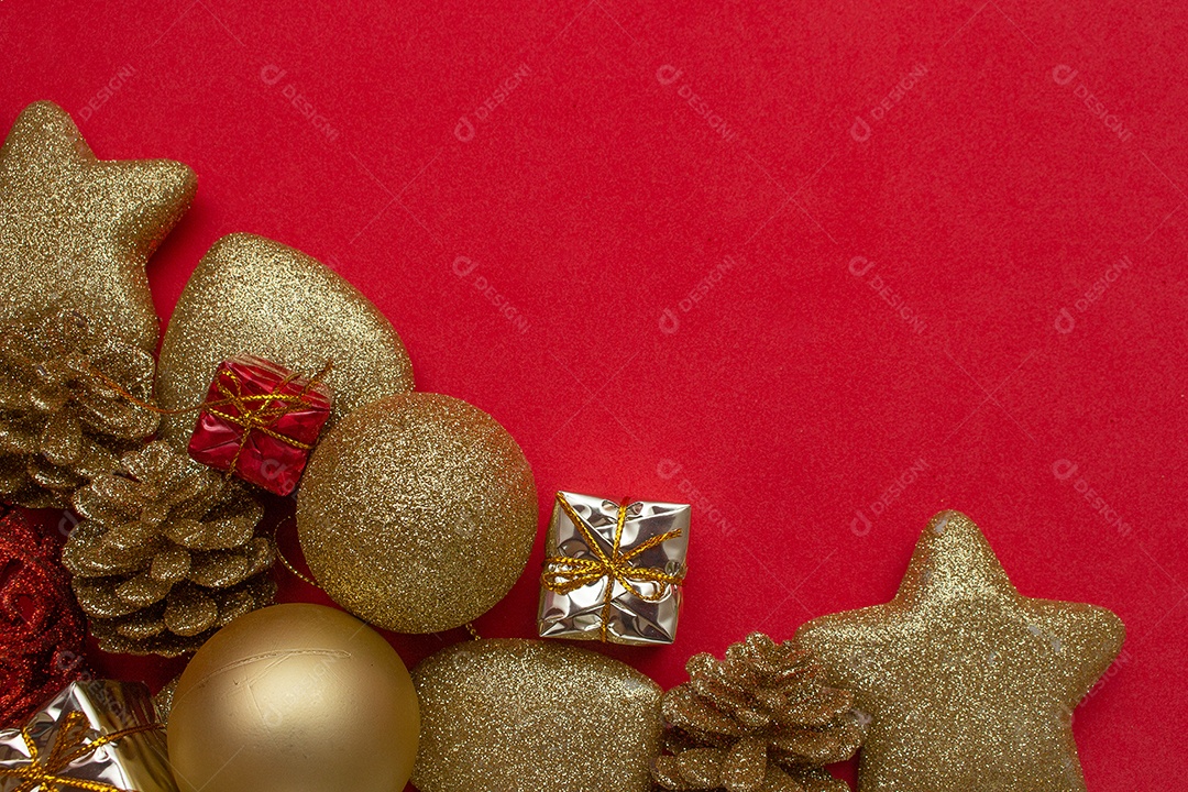 vários enfeites de natal dourados em fundo vermelho